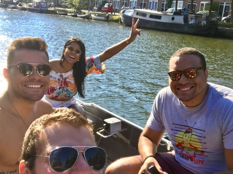Drei Frauen und ein Mann in weißer Kleidung auf einem Boot, Boats4rent-Mitarbeiter am Kai